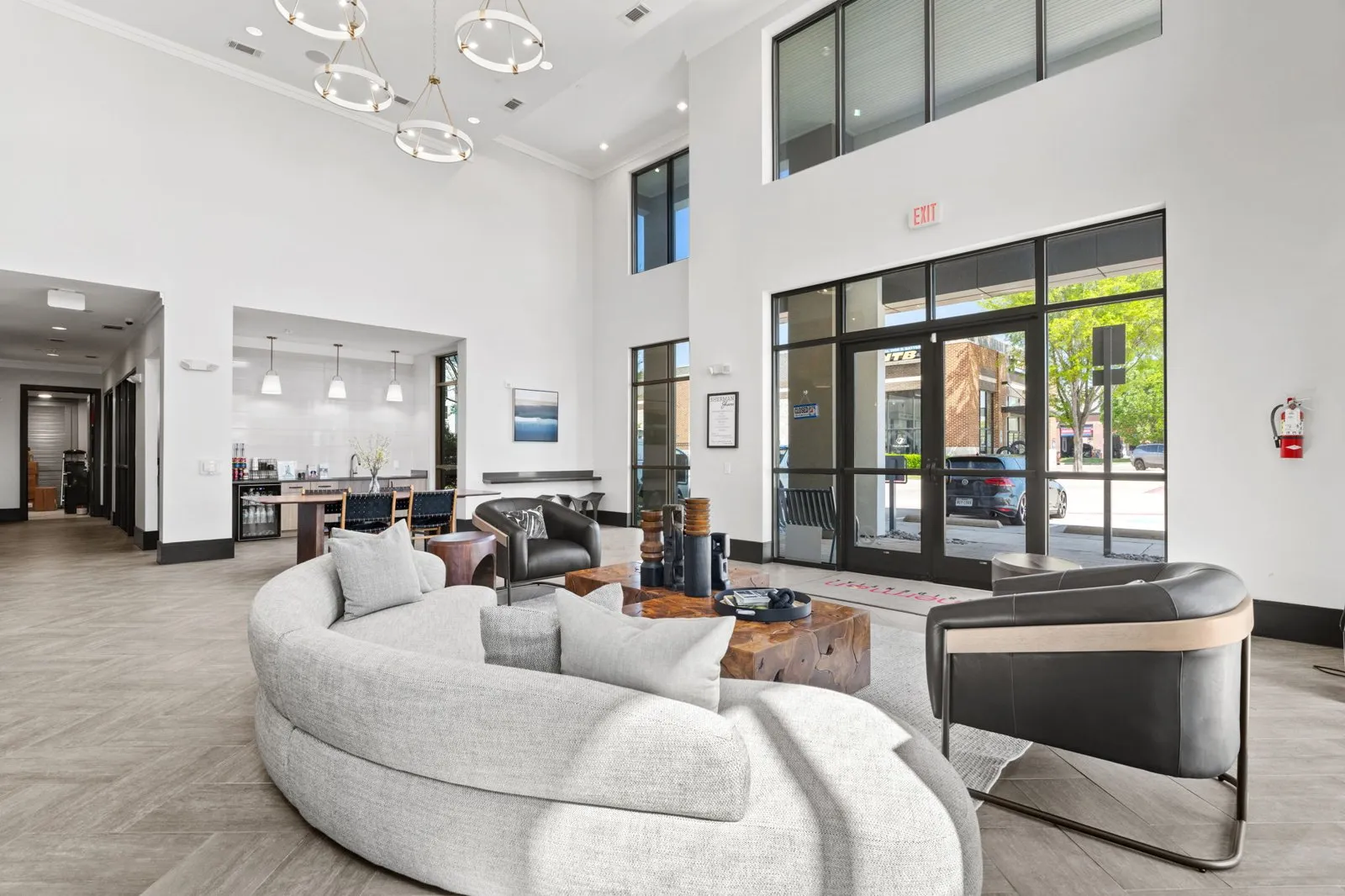 A modern living room with a curved sofa and a fireplace. at Axis at Watters Creek