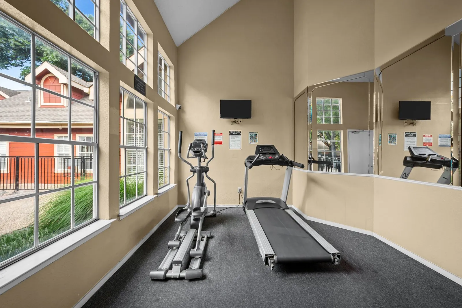 A gym with treadmills and exercise bikes. at Bravo Apartment Living