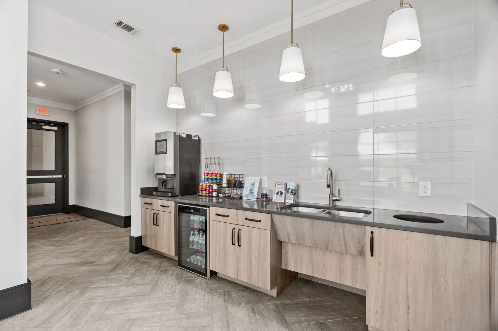 A kitchen with a refrigerator, sink, and cabinets. at Axis at Watters Creek