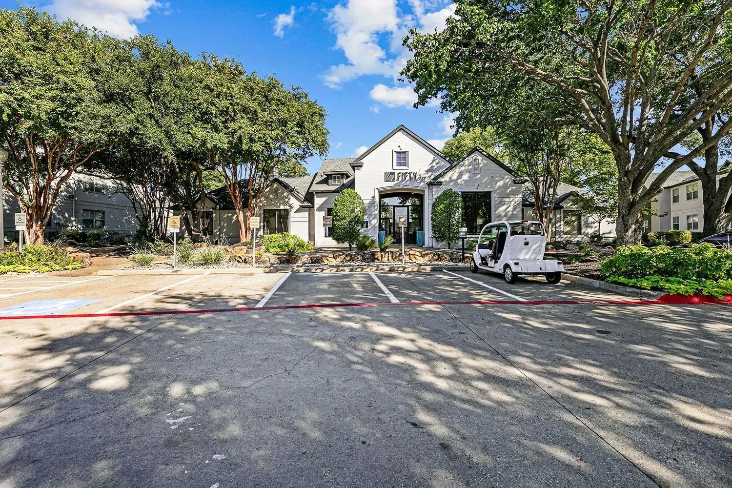 Community entrance drive framed by mature trees at 29Fifty