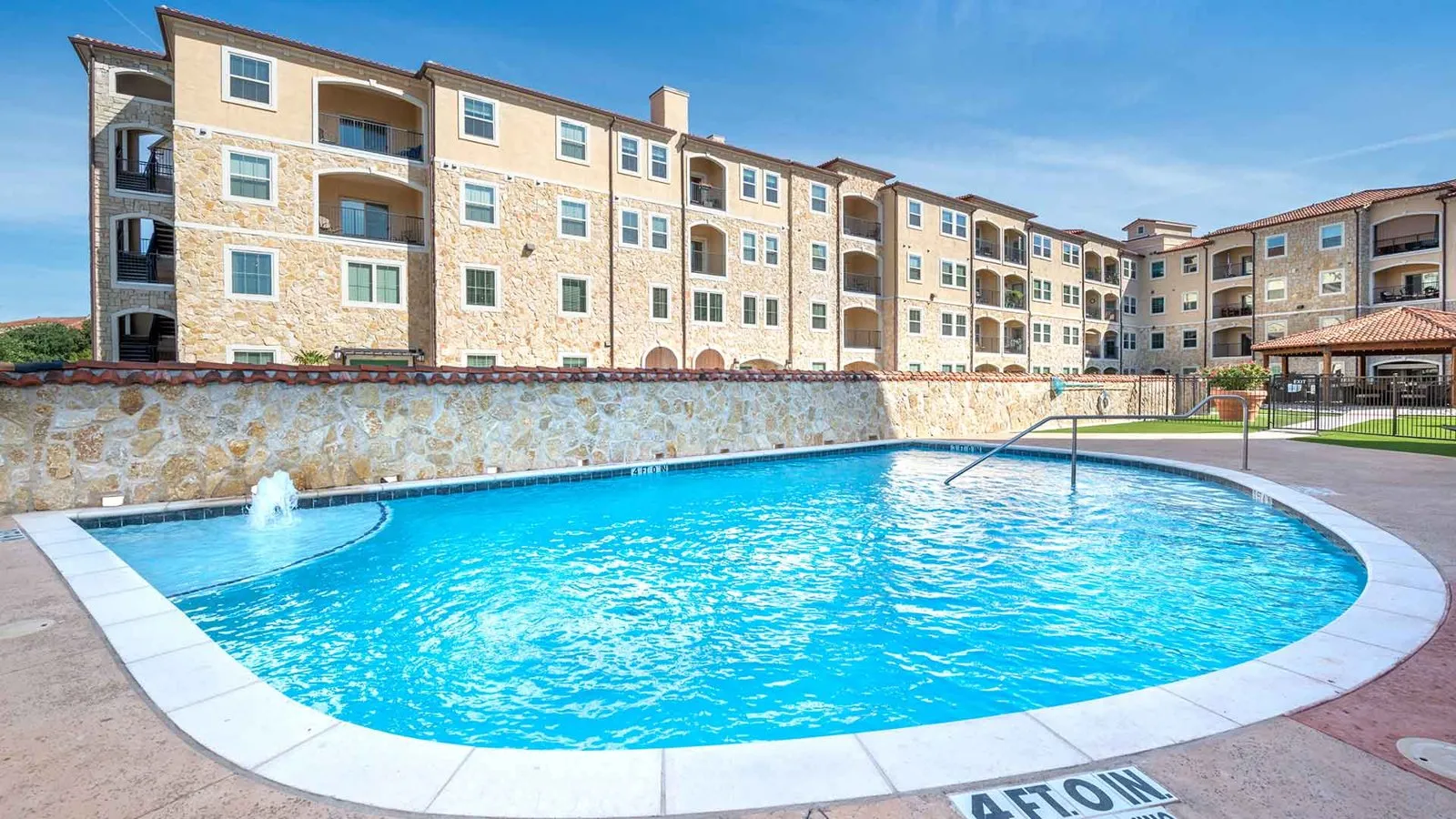 Standing before the pool with the apartment building in the background and the gazebo to the far right. at Bell Tower Reserve