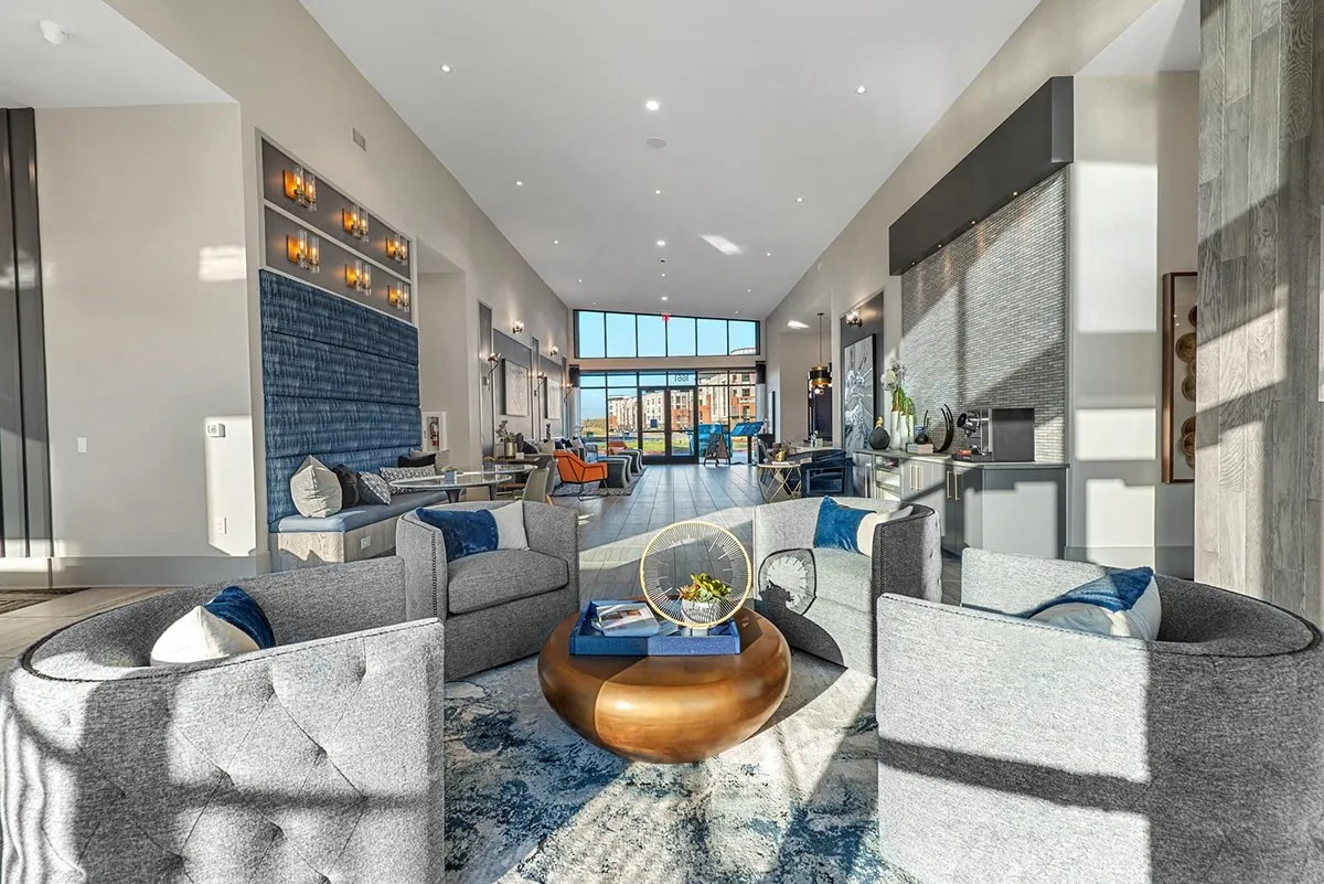 A modern living room with a large grey sofa and a coffee table. at Axis Grand Crossing