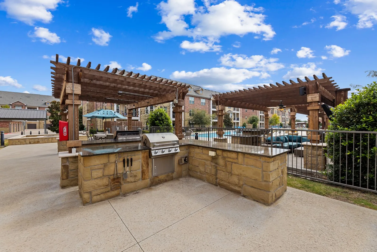 Outdoor grilling stations by the resort-style pool at Auberge of Burleson