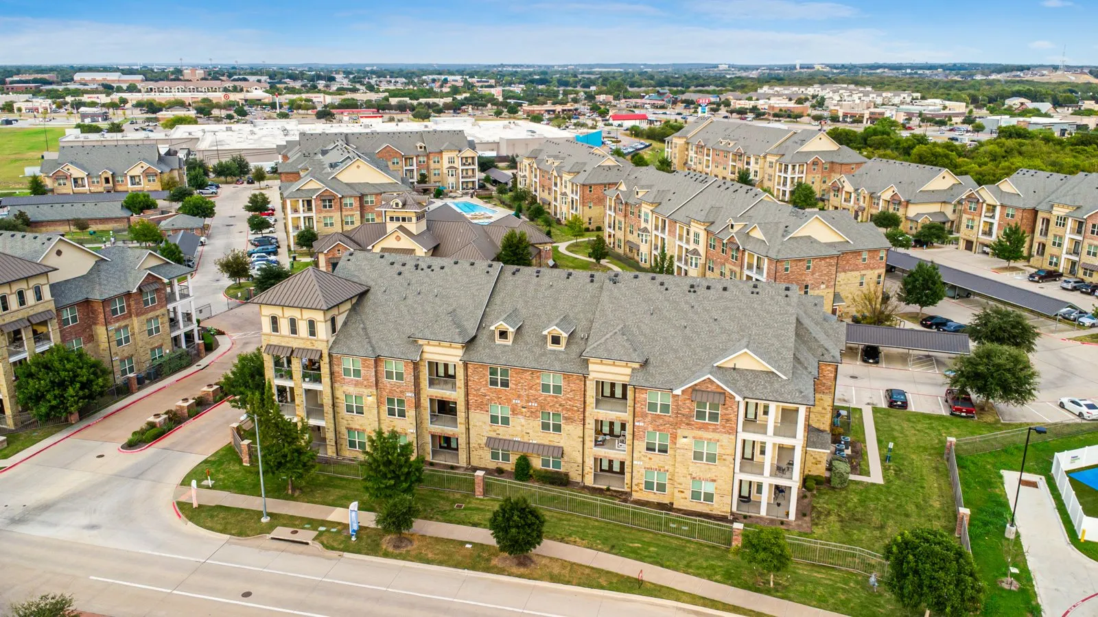 Aerial view of Auberge of Burleson apartments in Burleson TX with resort-style swimming pool and landscaped grounds. at Auberge of Burleson