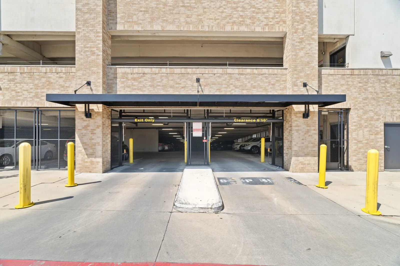 A parking garage entrance with a sign th at Axis at Watters Creek