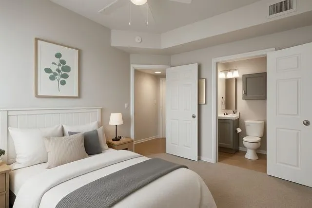 Model bedroom with neutral bedding and natural light at 29Fifty
