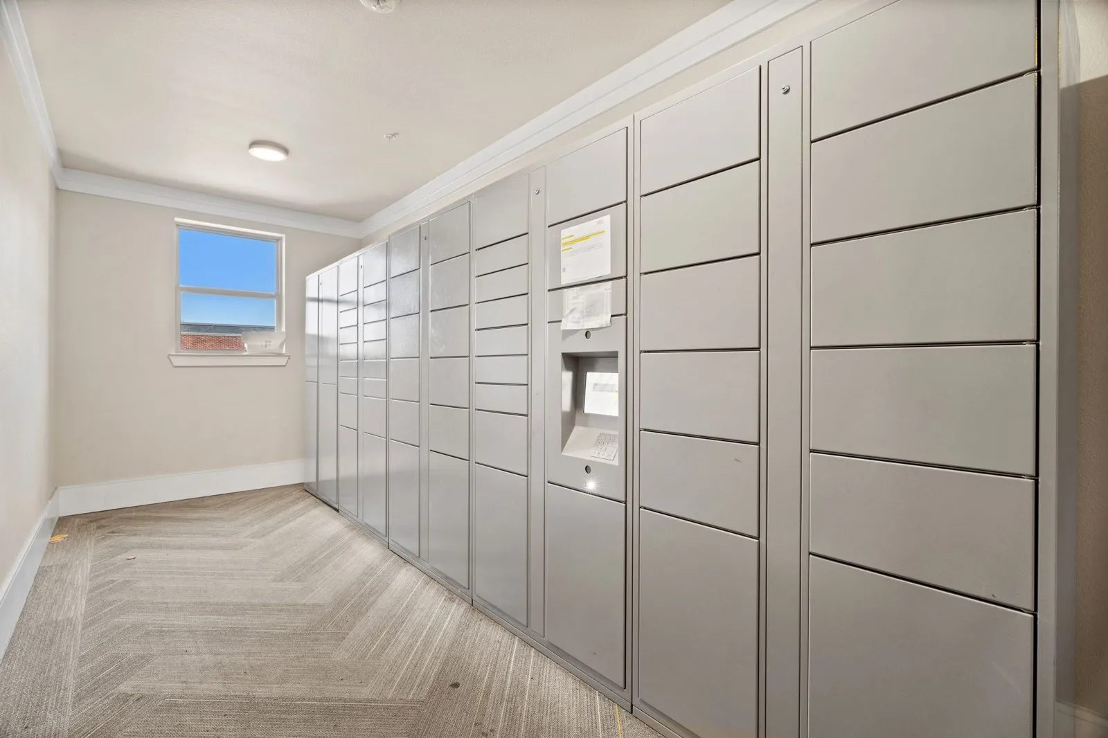 A hallway with a row of lockers on the right side. at Axis at Watters Creek