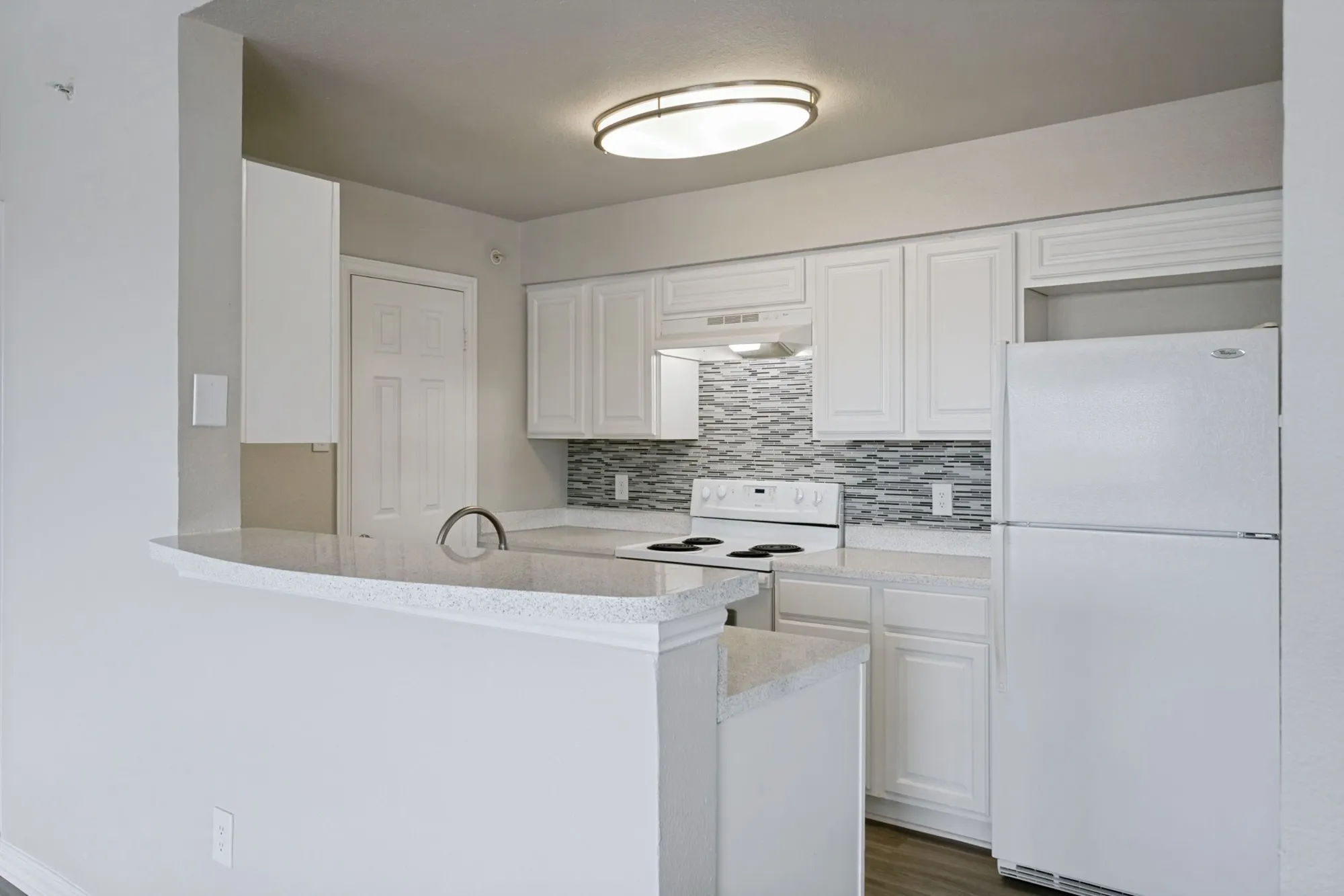 Kitchen with white cabinetry and tile backsplash at 29Fifty