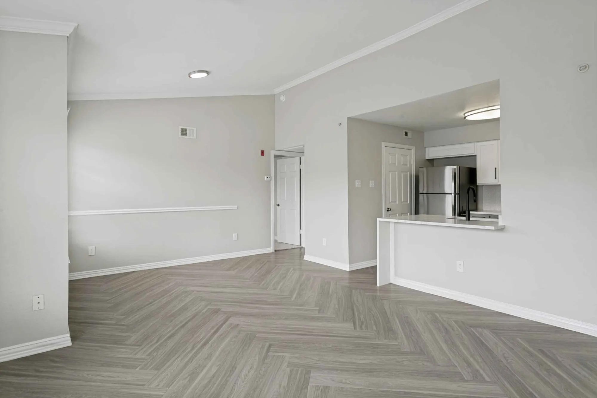 Open living and dining area with herringbone flooring at 29Fifty