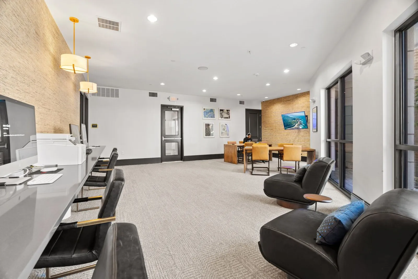 A waiting area with black leather chairs and a white reception desk. at Axis at Watters Creek