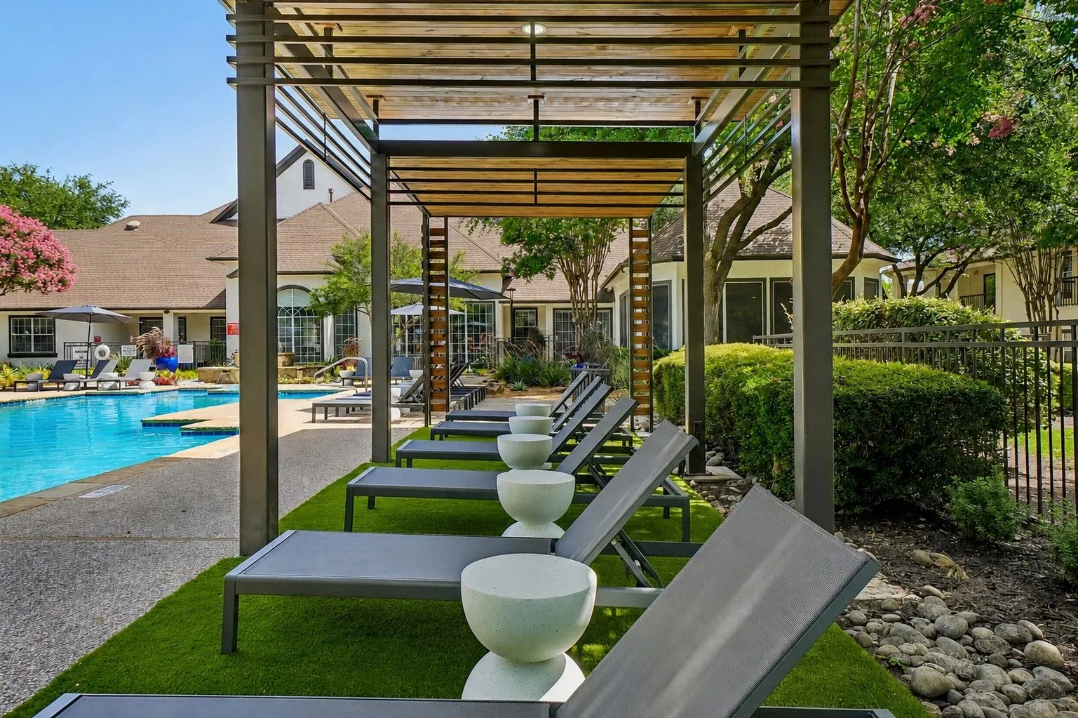 23Hundred at Ridgeview - A serene poolside area with lounge chairs and lush landscaping