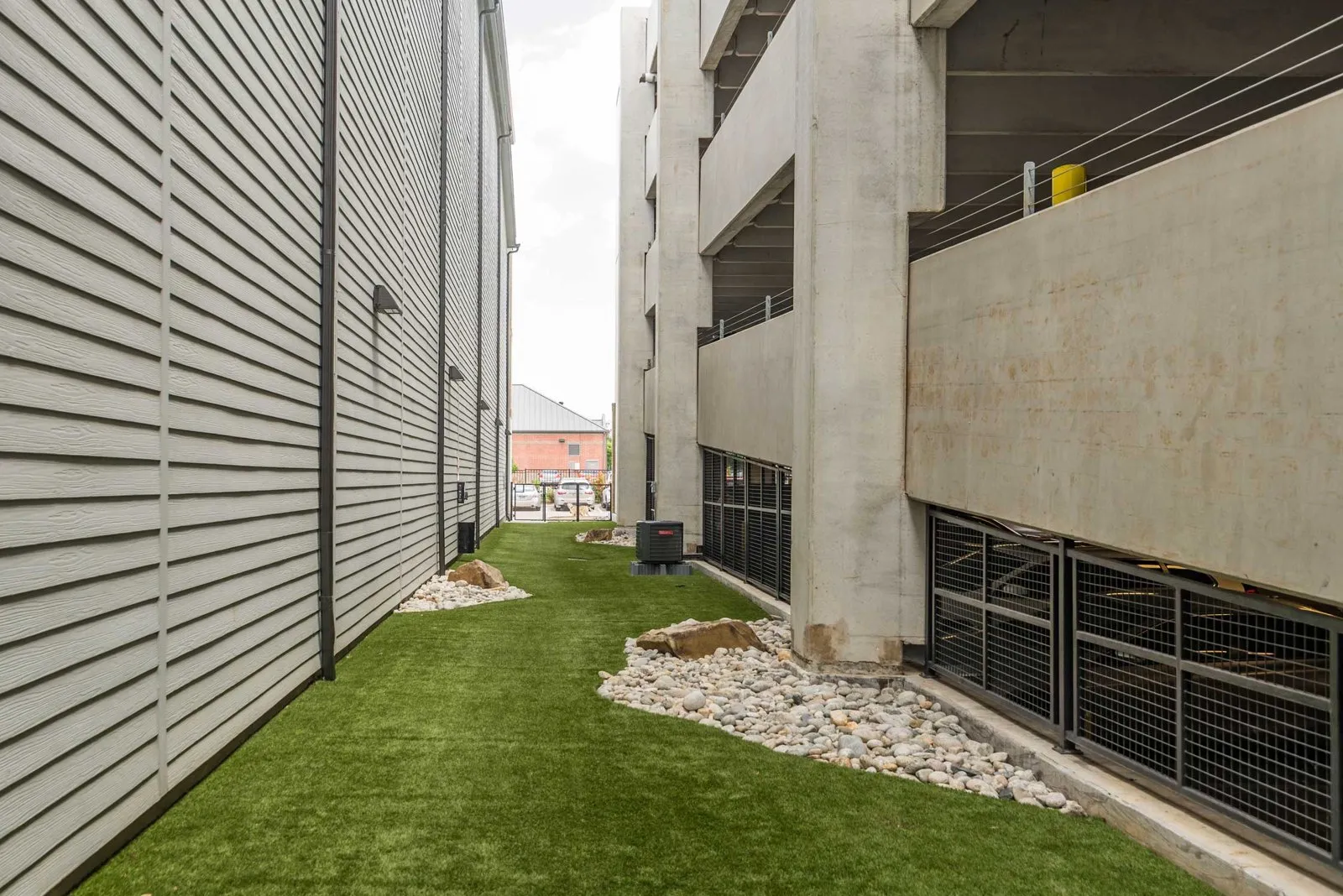 A concrete building with a green lawn in front. at Axis at Watters Creek