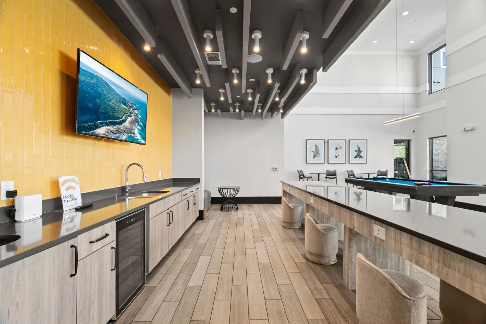 A modern kitchen with a long counter and a painting hanging above it. at Axis at Watters Creek