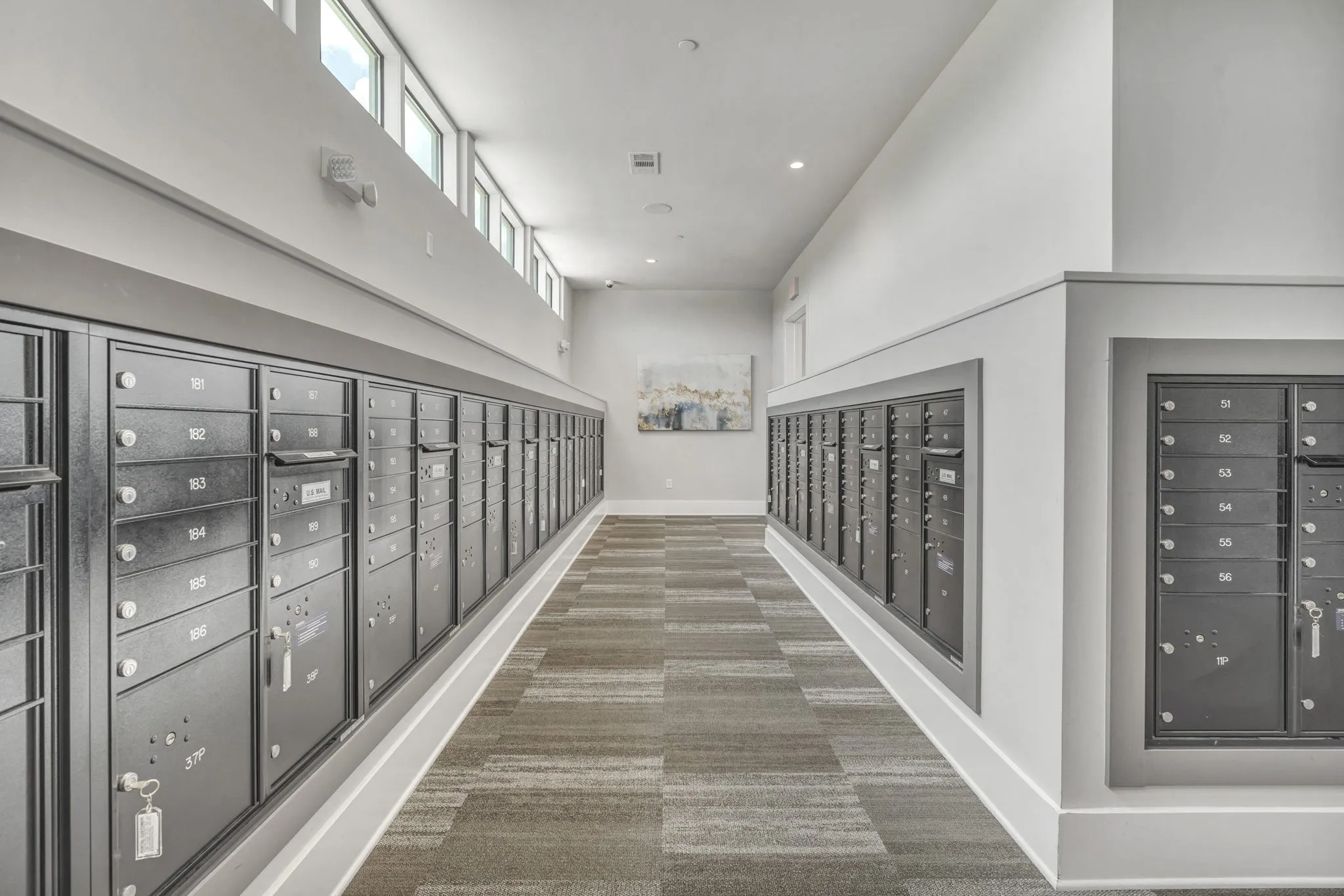 26 at City Point - A long hallway with a carpeted floor and a series of lockers on both sides