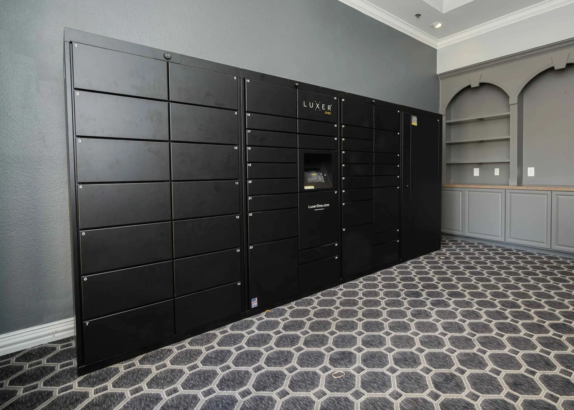 23Hundred at Ridgeview - A sleek black package delivery locker system in a modern setting with patterned flooring